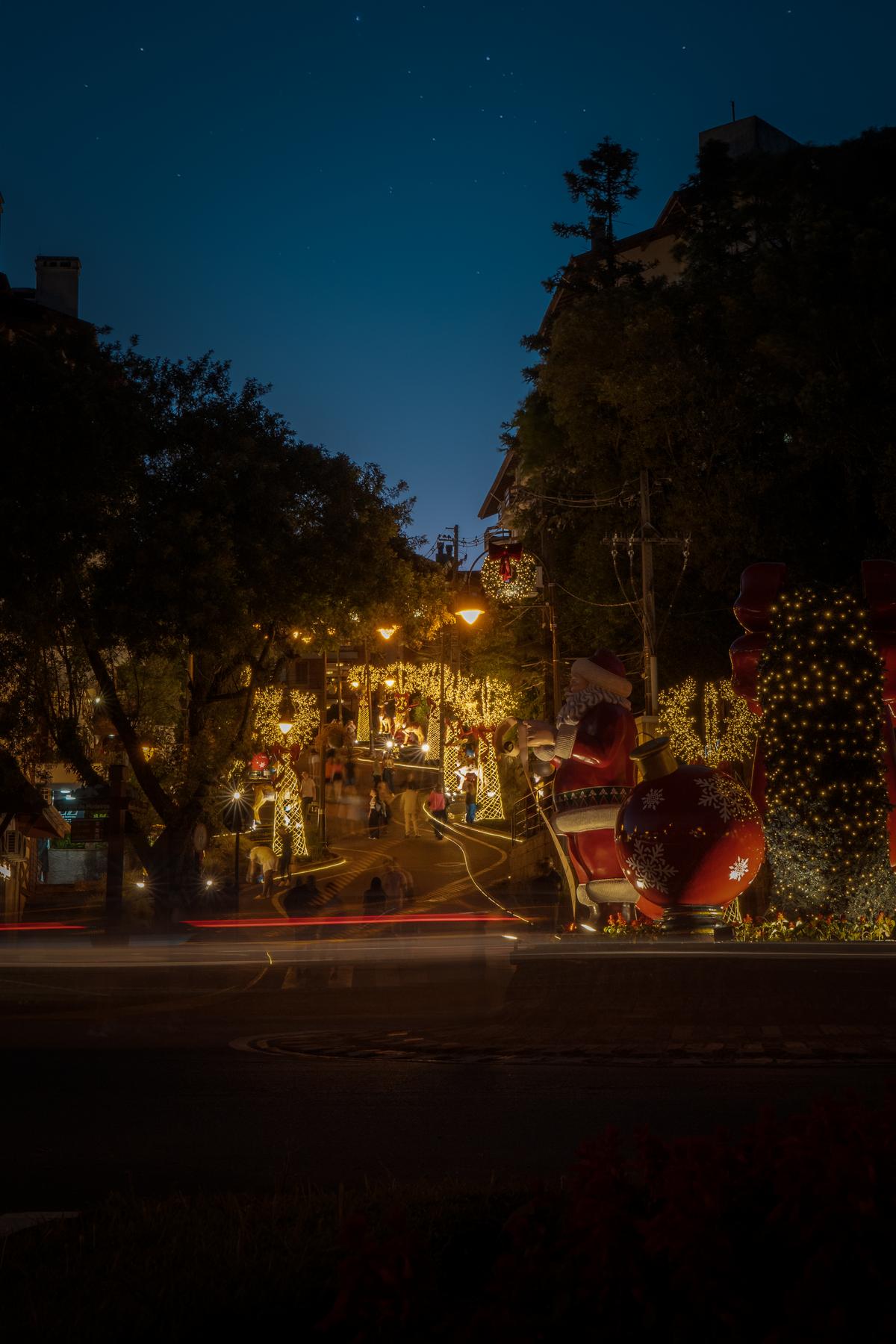 Imagem de um corretor de imóveis apresentando modelos de casas disponíveis para compra em Gramado, com mapa da cidade ao fundo.